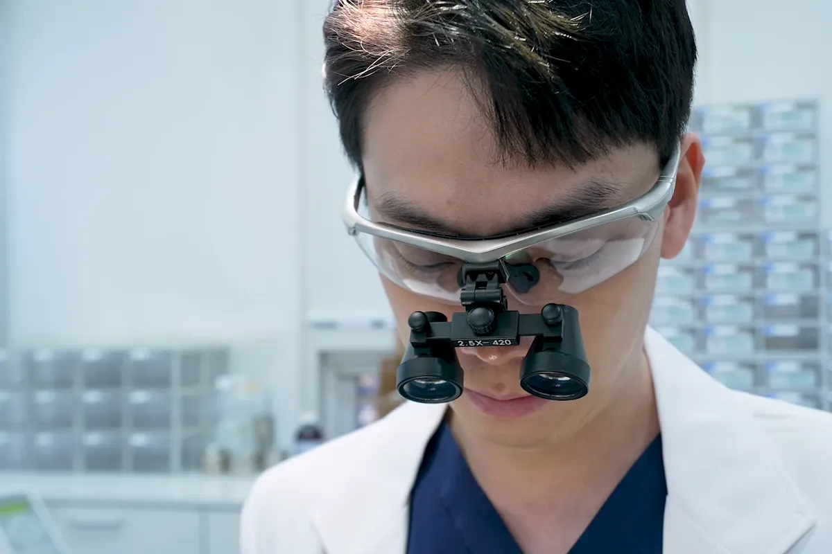 마곡 잇몸치료 — 확대경을 쓰고 잇몸을 살피는 대표원장